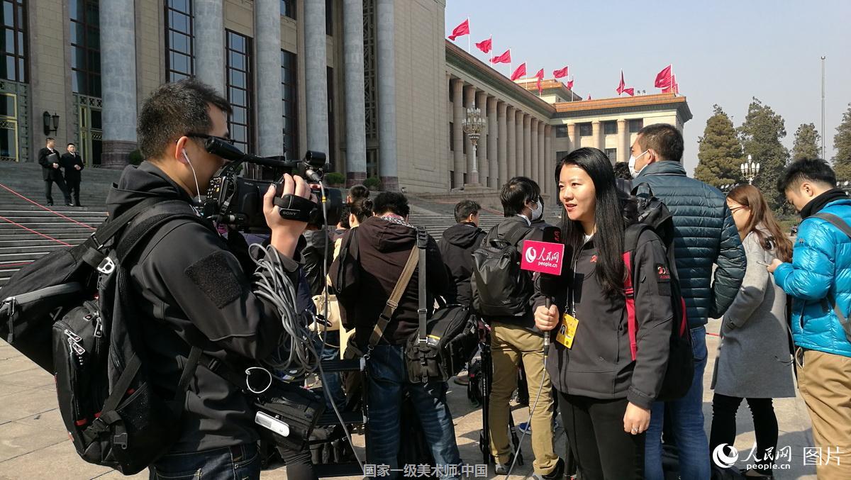 全国政协十二届五次会议开幕会:人民网记者正在大会堂前做直播